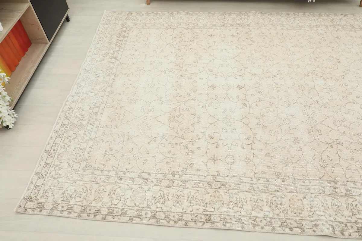 Opposite corner view of the large ivory rug with subtle floral designs