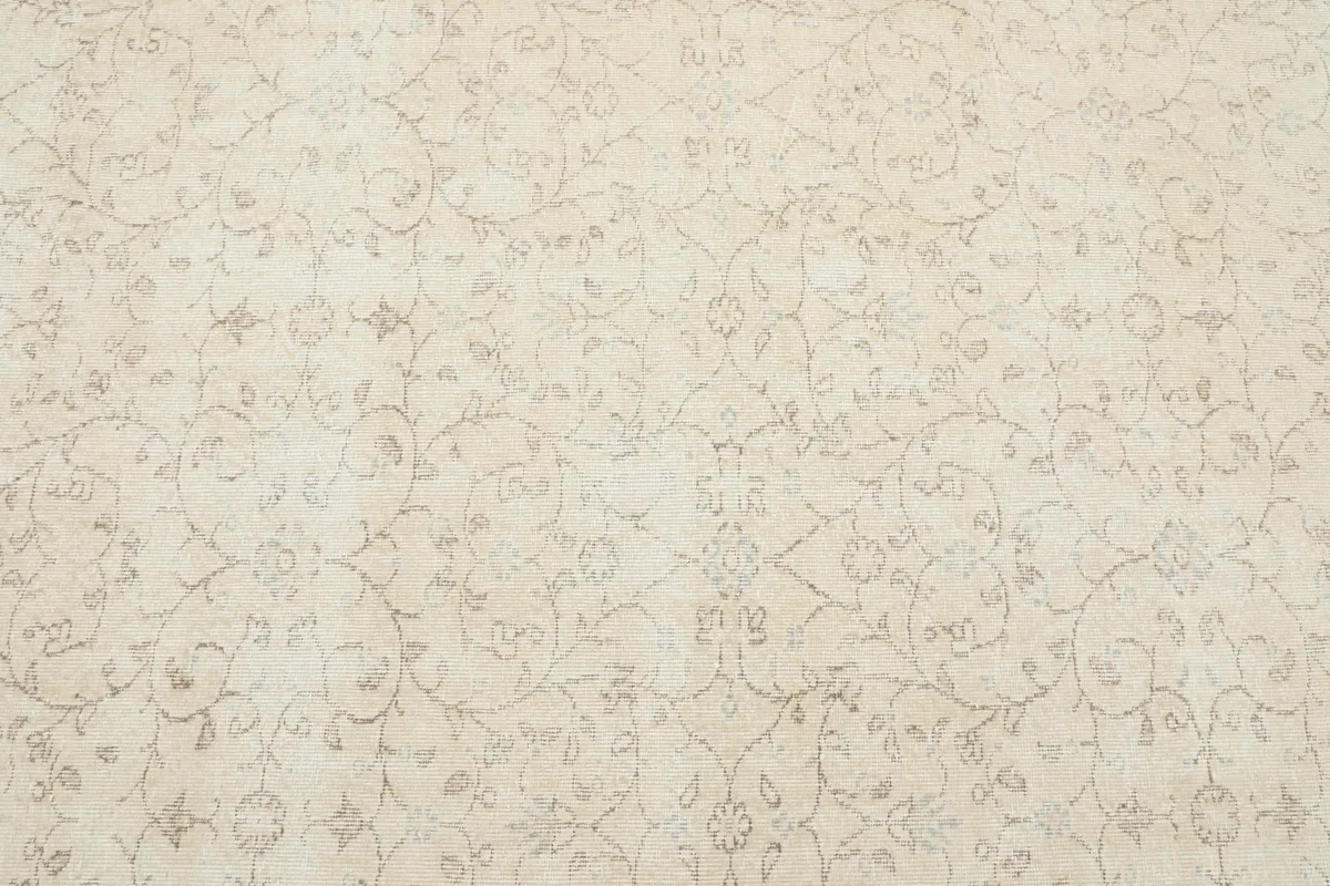 Close-up of the rug's central field with faded floral and geometric motifs
