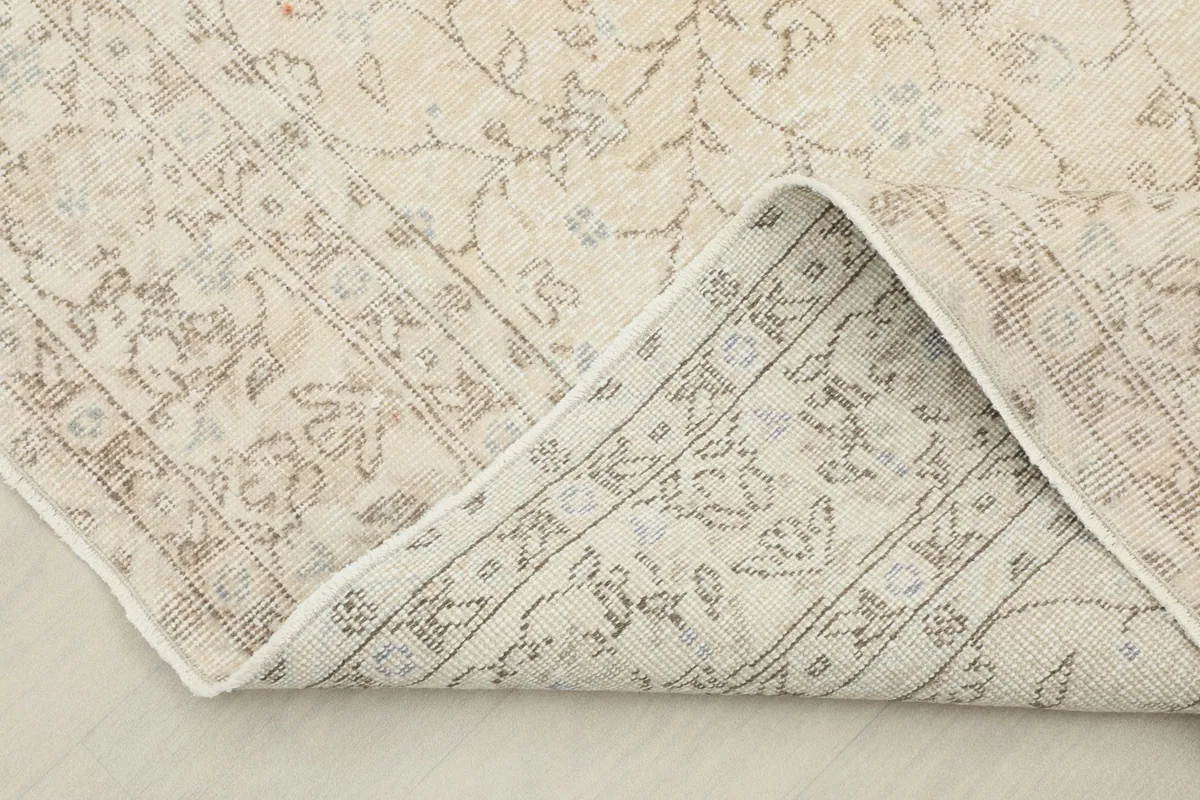 View of the rug's corner folded back, showing the cotton foundation