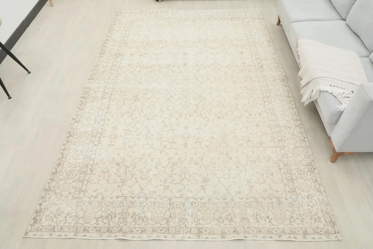 Overhead view of the vintage ivory rug laid out in a room, showcasing its full design