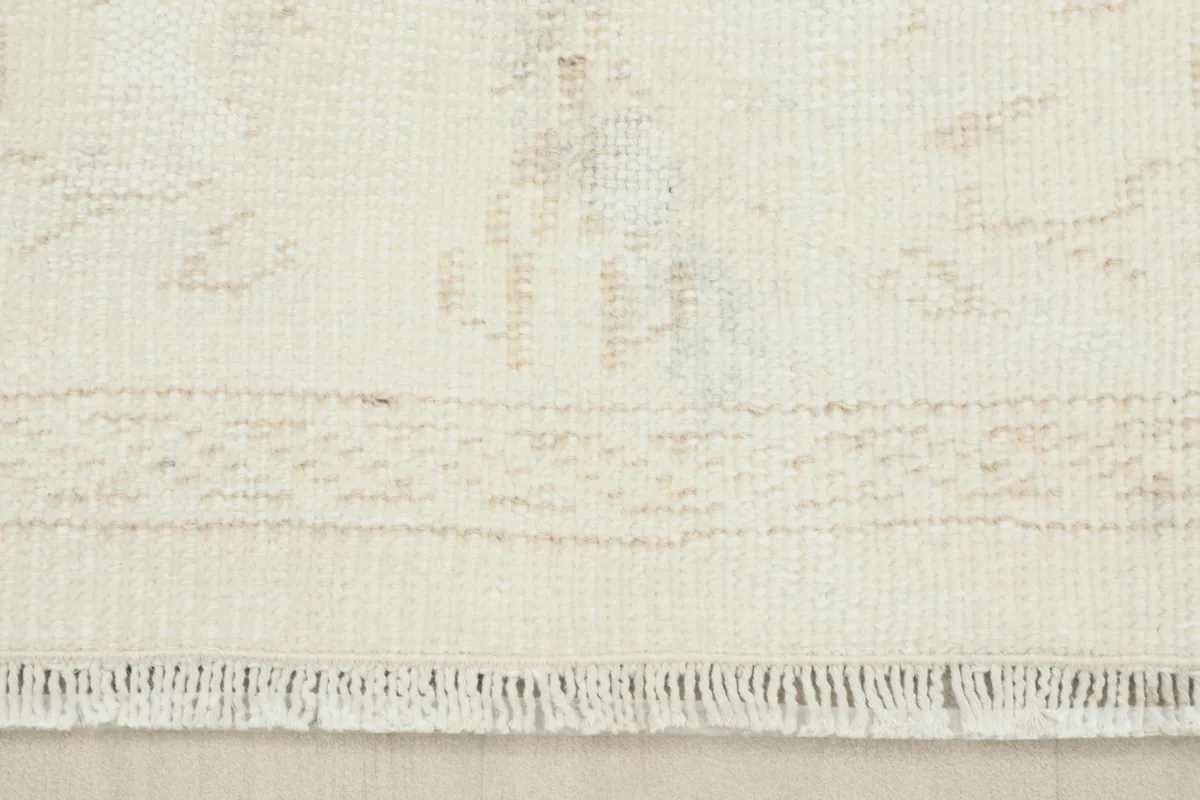 Close-up of the rug's short, delicate fringes and a section of the border pattern.