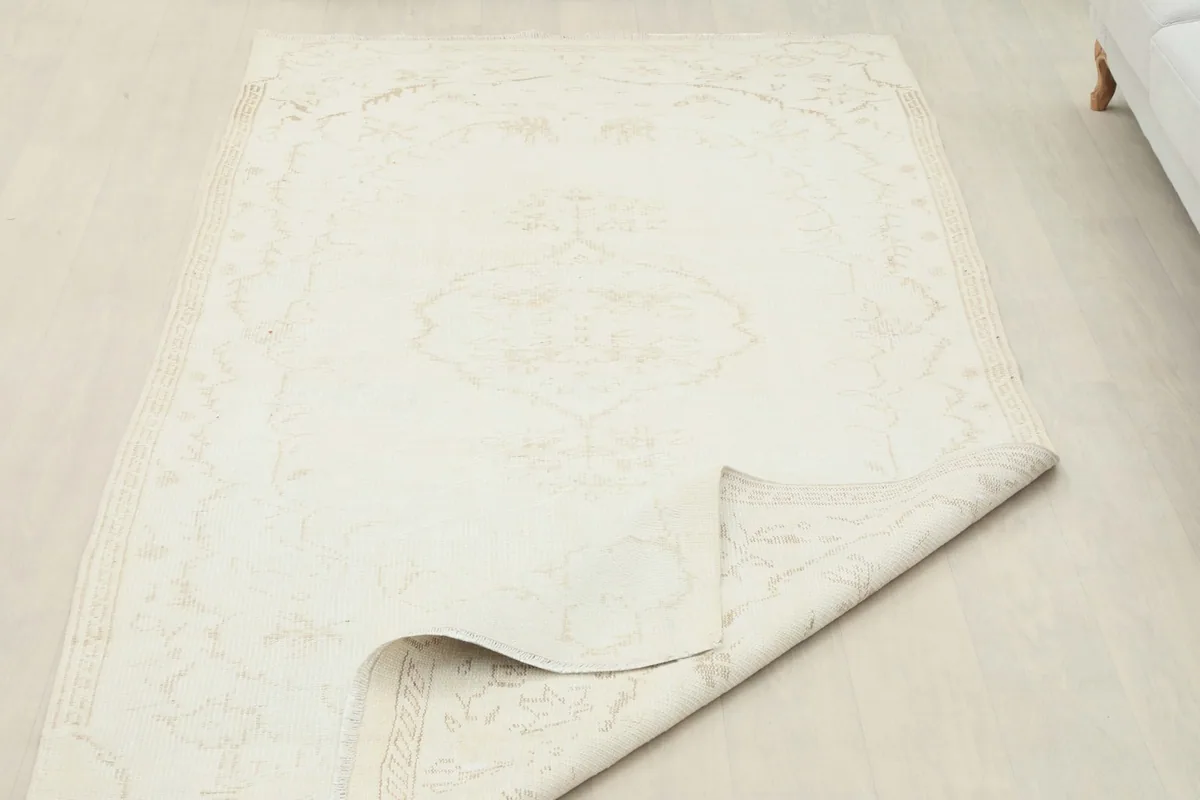 The rug is partially folded back, revealing its thickness and the consistent pattern on the reverse side.