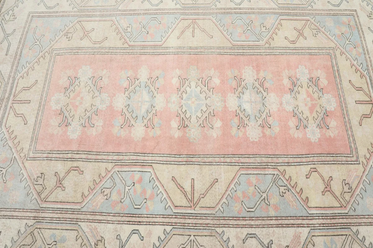 Detailed view of the central rose field and the repeating motifs within the vintage rug