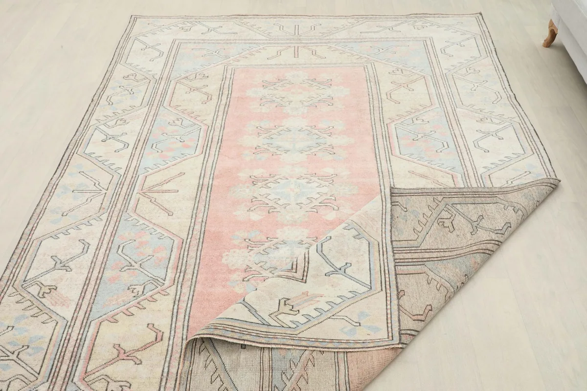 Rug partially folded, illustrating its flexibility and the reverse side of the hand-knotted construction