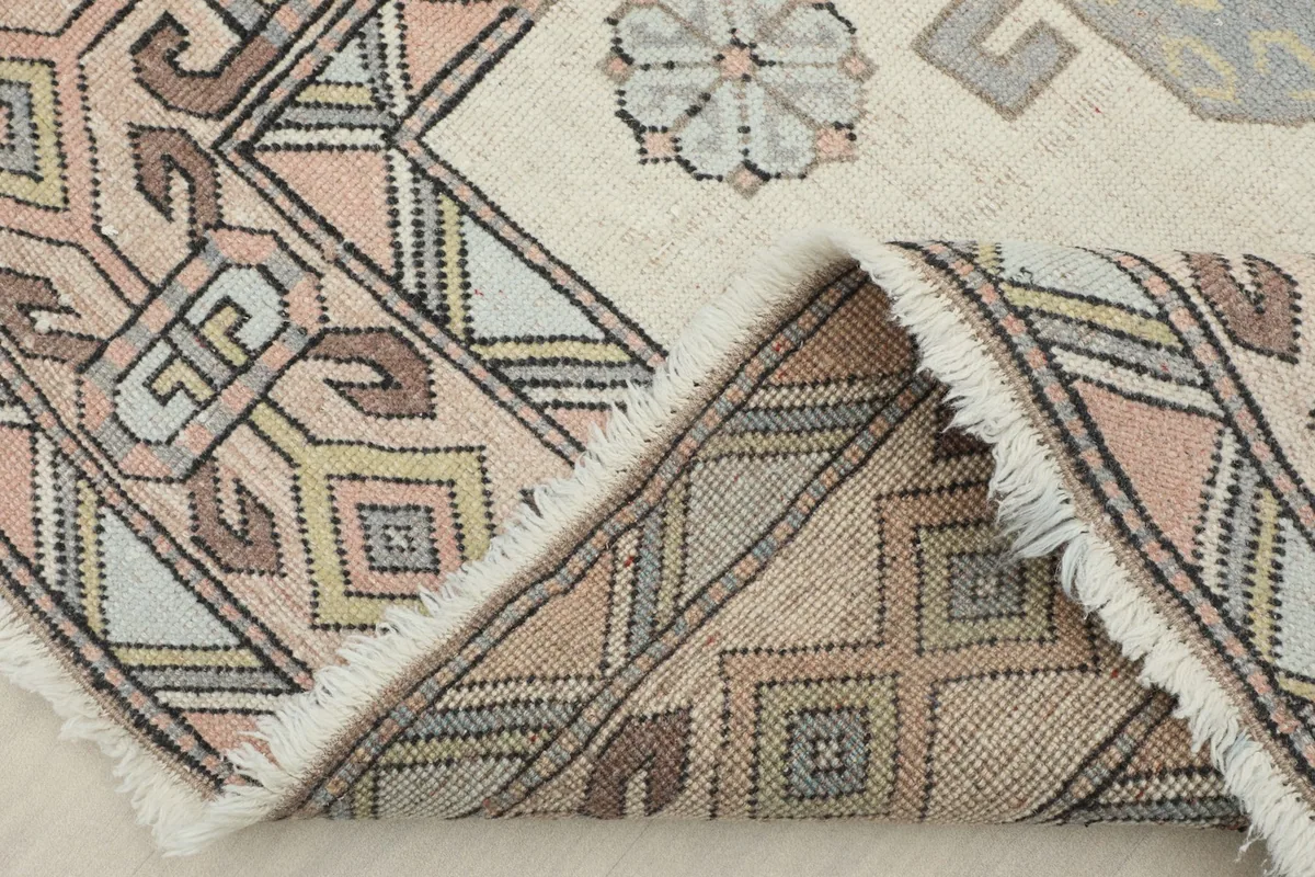 View of the rug folded to show the hand-knotted wool pile and cotton foundation