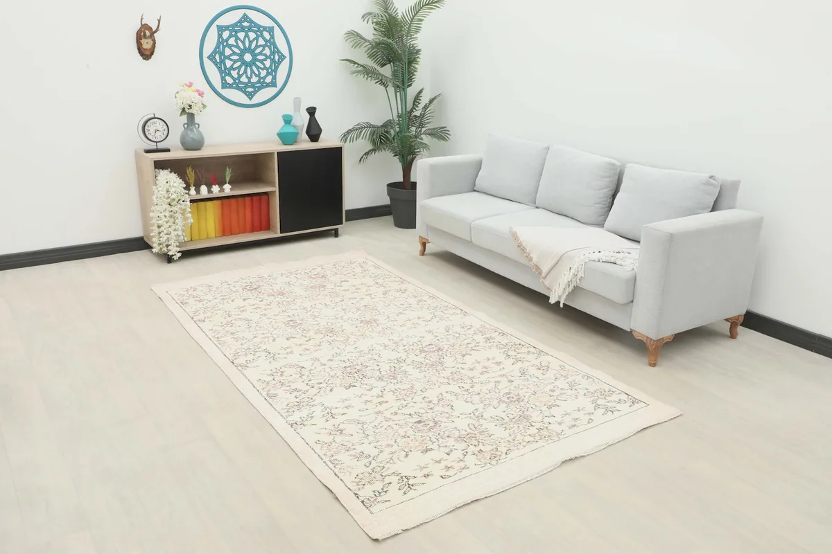 Ivory floral rug in a modern living room setting with a light gray sofa and minimalist decor