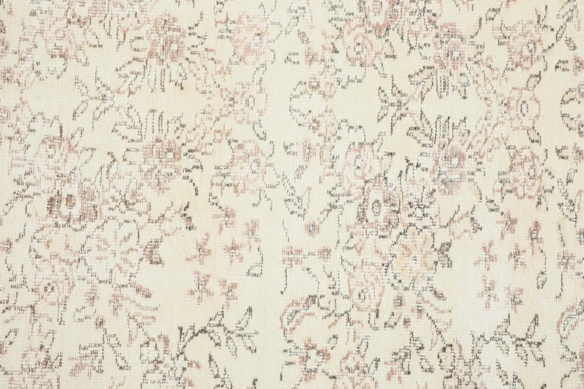 Detailed overhead view of the rug's floral pattern, showing the varying shades of rose, brown, and gray