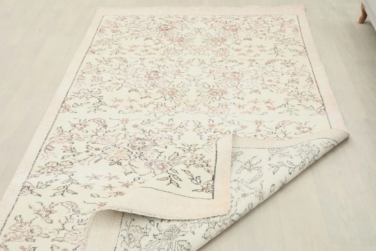 Rug with a corner folded back, displaying the intricacy of the hand-knotted construction and the foundation