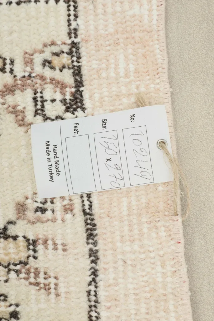 Close-up of the rug's tag with size information and 'Hand Made in Turkey' detail