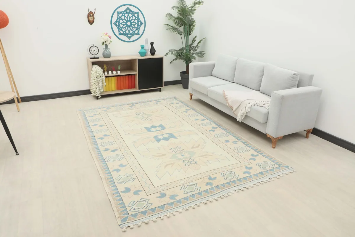 Vintage Anatolian area rug displayed in a room setting with a light-colored sofa