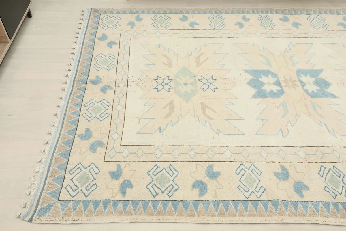 Close-up of the upper left corner of the rug, showing tribal patterns and fringe