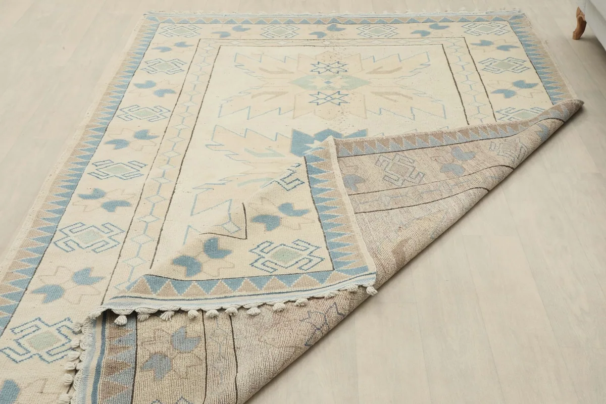 The rug partially folded back, displaying the reverse side and the hand-knotted construction