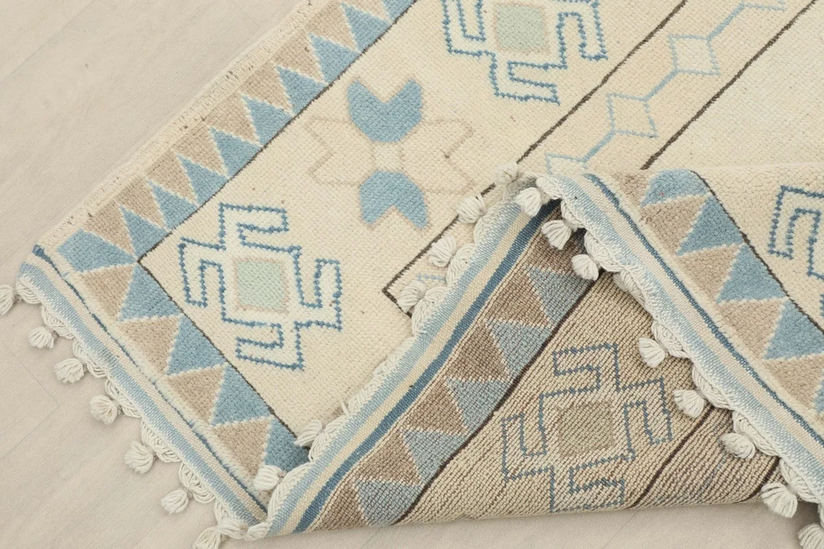 View of the rug folded to reveal the back, showing the hand-knotted cotton foundation