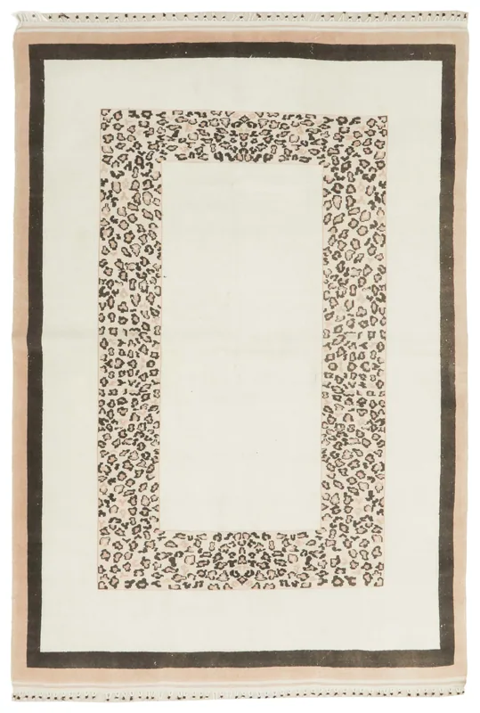 Full overhead view of the 5'7" x 8'3" ivory vintage Anatolian rug with black and beige leopard border.