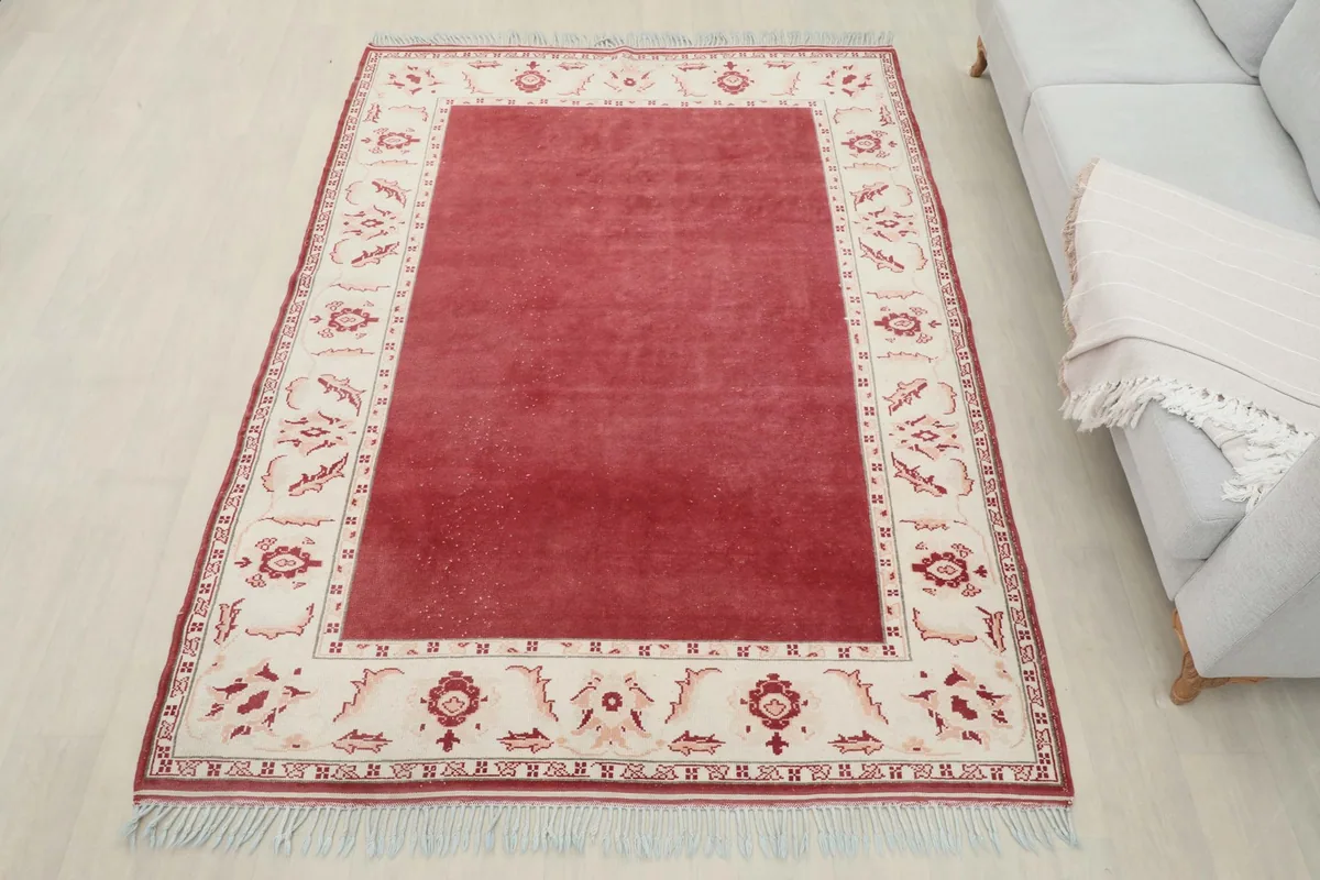 Full view of the 5'7" x 7'5" red vintage rug in a room, offering a sense of scale and placement.