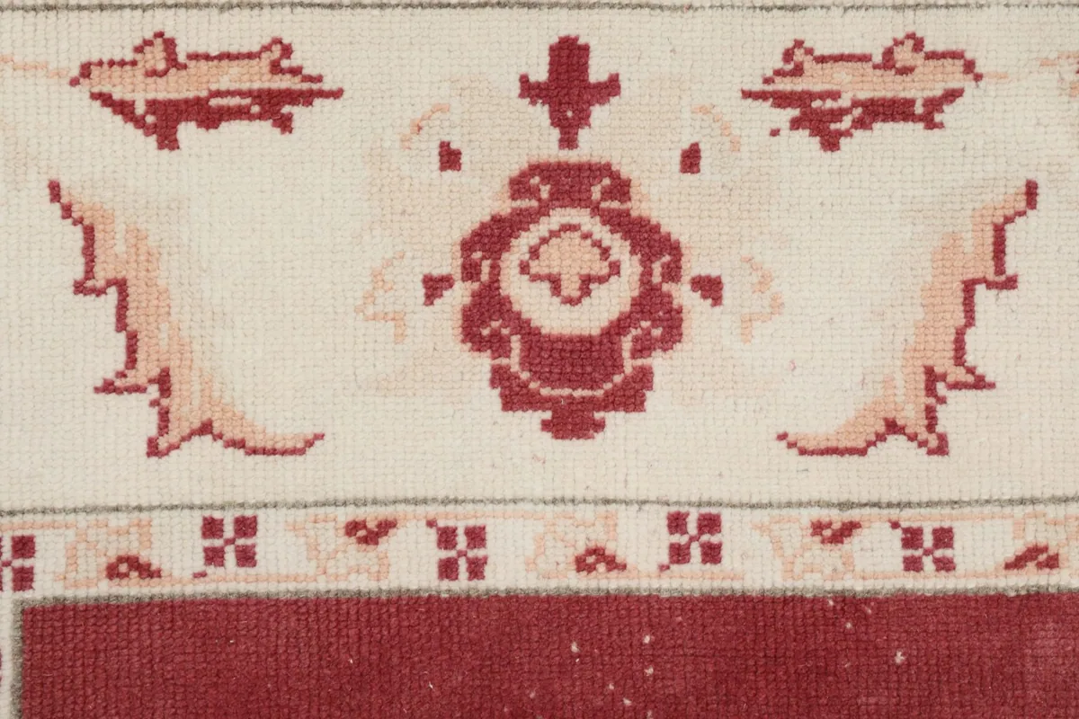 Detailed close-up of a rose and tan floral motif within the ivory border.