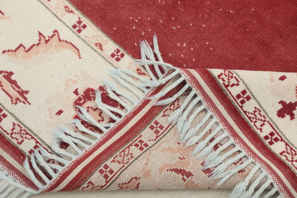 Folded corner of the rug showing the thickness of the wool pile and cotton foundation.
