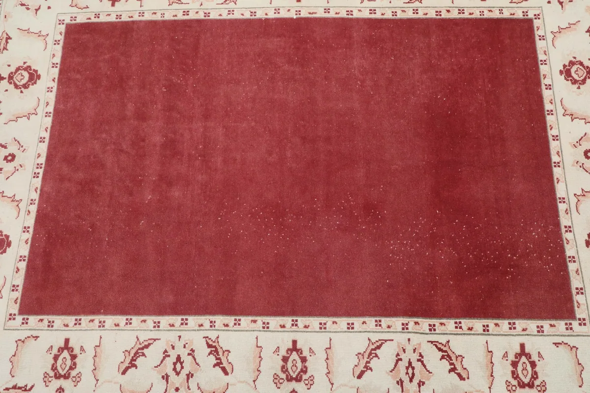 Overhead view focusing on the central red field and the surrounding ivory border details.