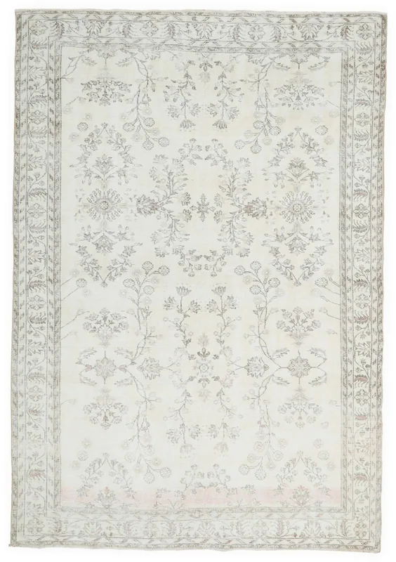 Full overhead view of a large cream and gray vintage Anatolian rug with floral patterns.