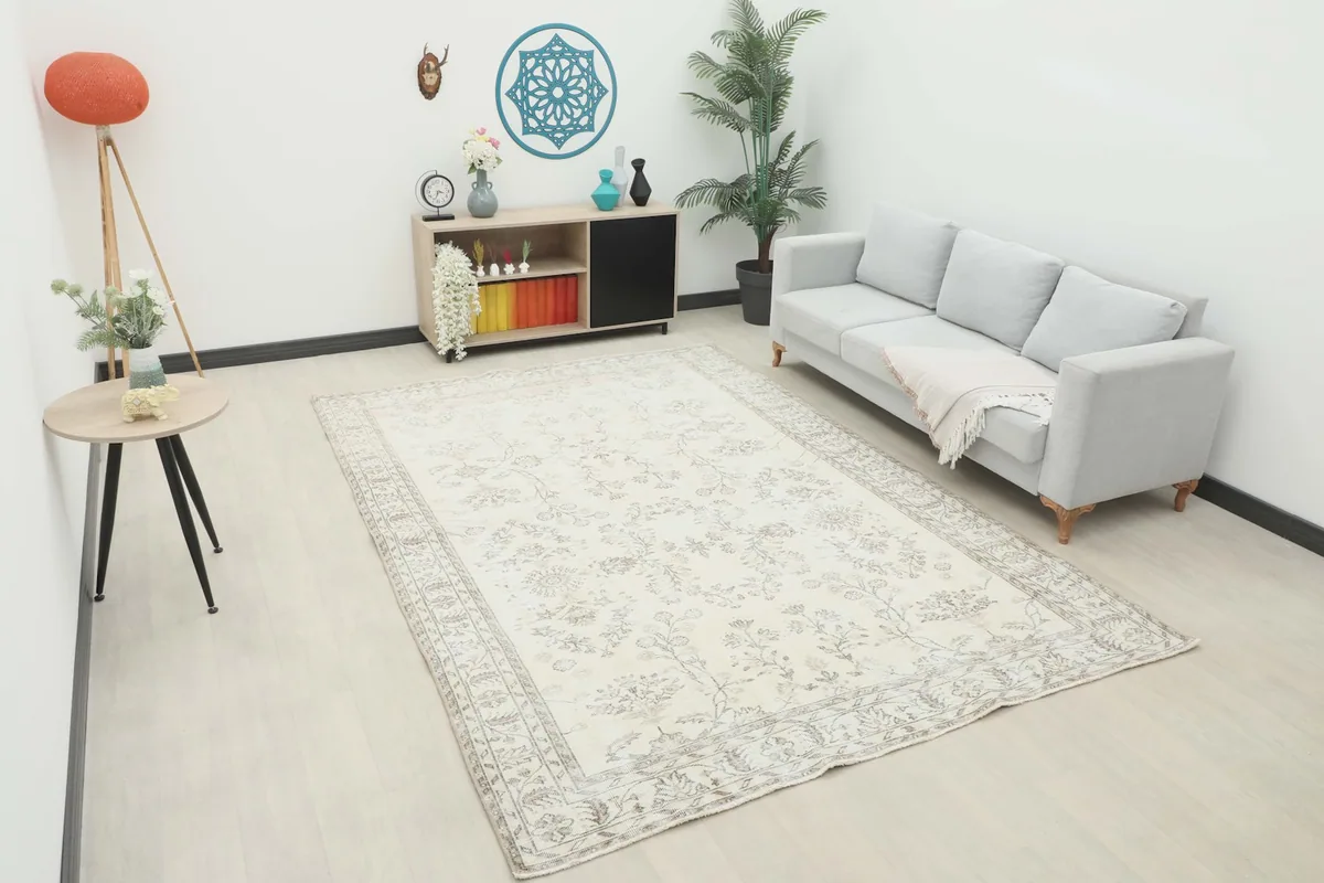 Large cream and gray rug placed in a living room setting with a light gray sofa.