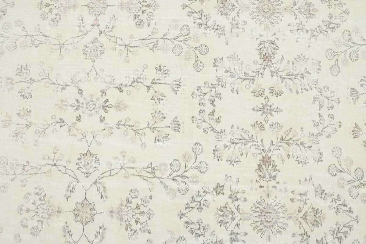 Detailed close-up of the rug's central floral and geometric patterns in cream and gray.