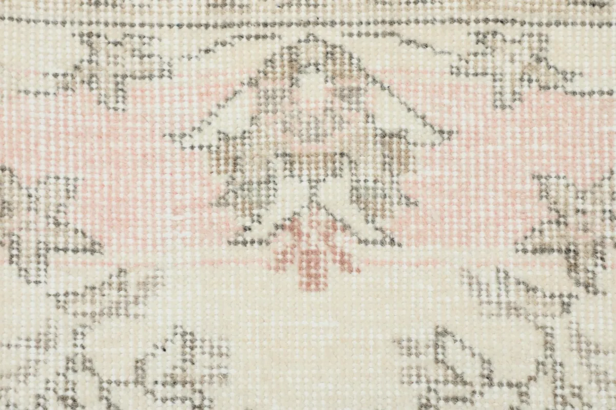 Close-up detail of the rug's pile, showing the subtle rose tones and hand-knotted texture.