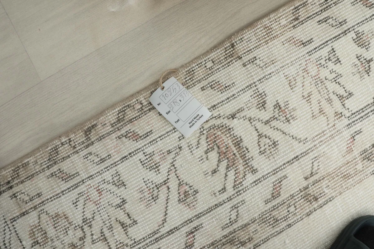 Close-up of the rug's back and edges, showing the tag and the hand-knotted construction.