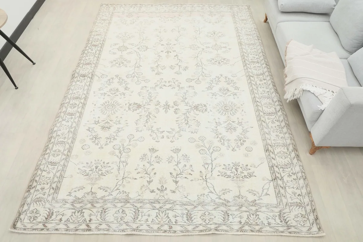 Full overhead view of the cream and gray area rug laid out in a room setting.
