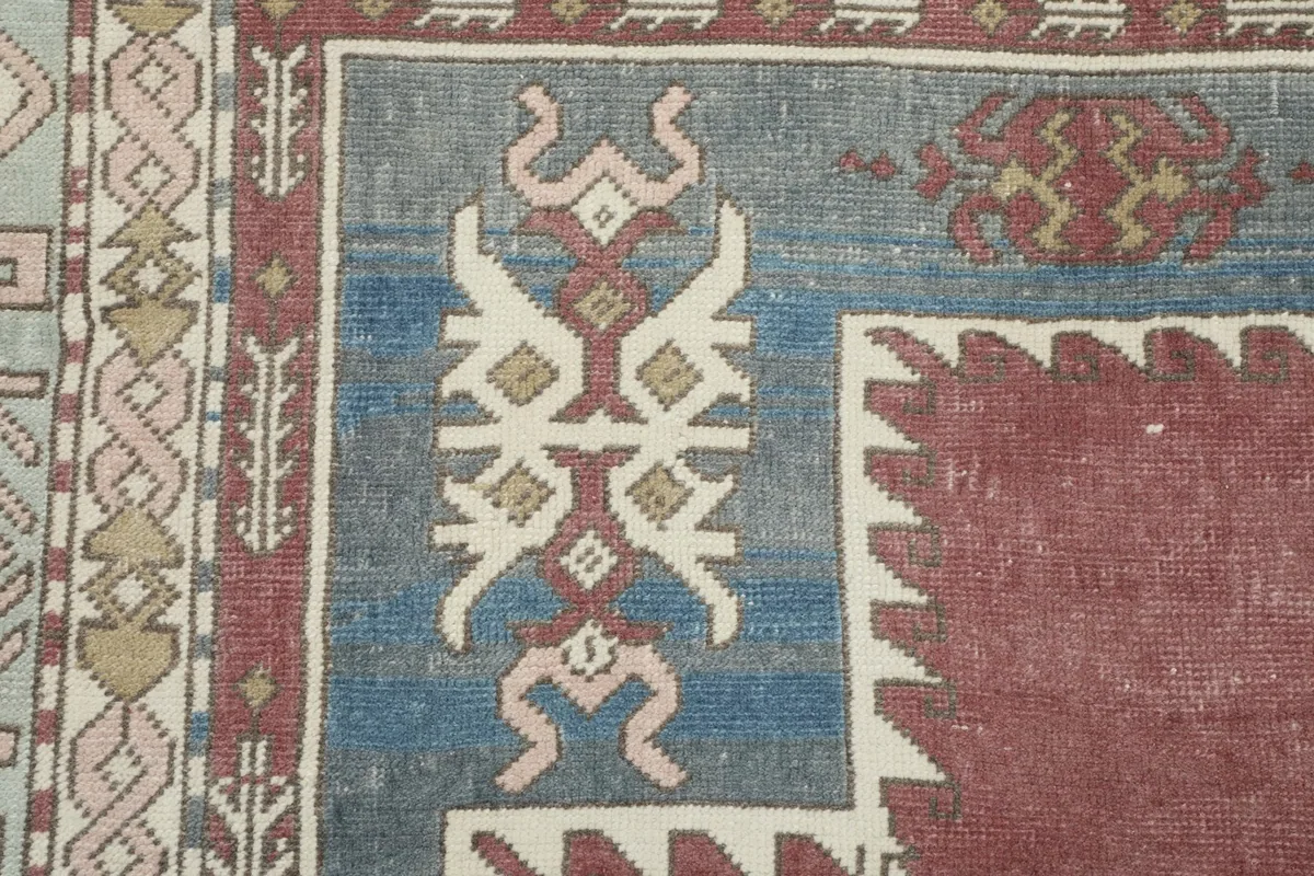 Close-up of a corner detail, displaying the blue field with geometric patterns and part of the inner border.