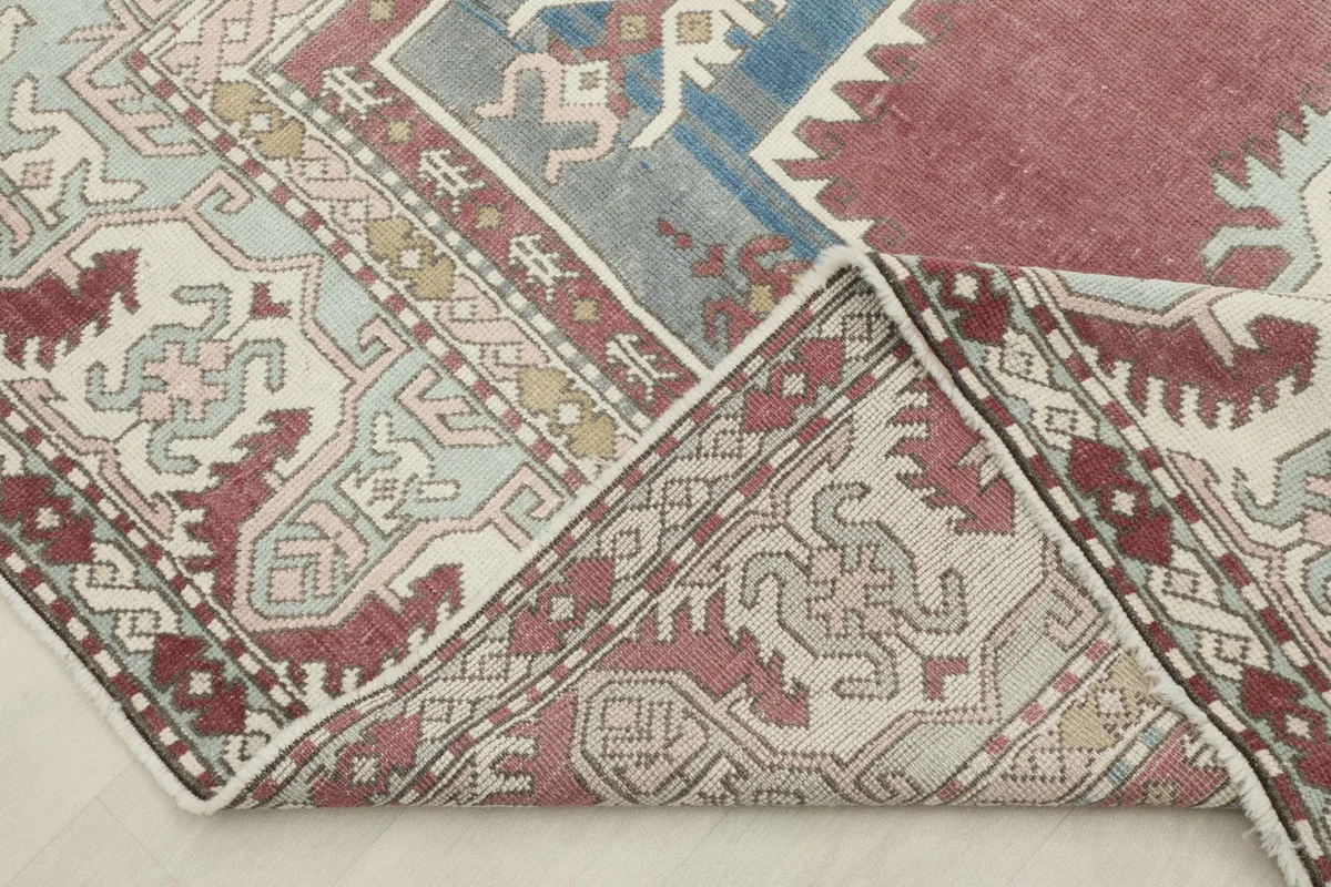 View of the rug folded back, revealing the reverse side of the hand-knotted cotton foundation and wool pile.