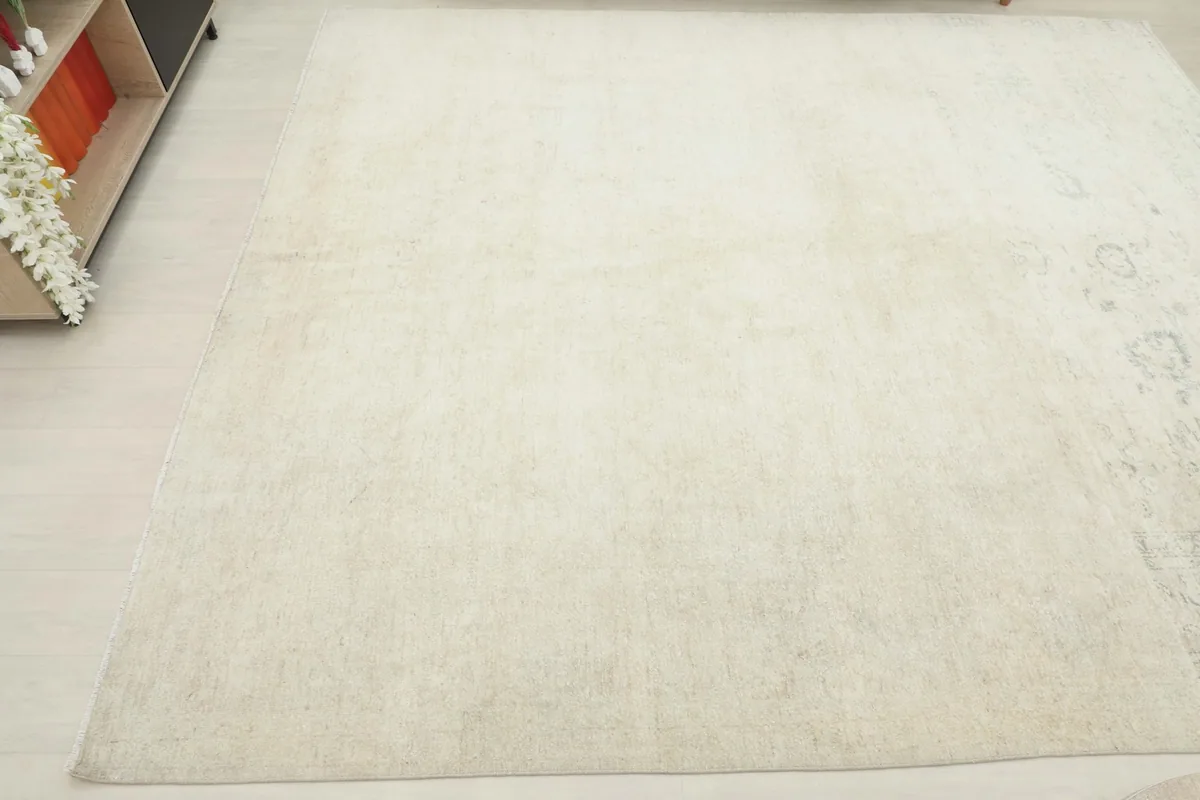 Another angled view of the ivory rug, focusing on the even distribution of its distressed appearance