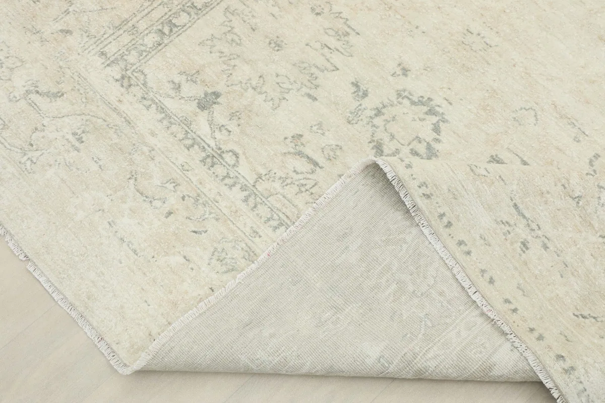 Corner of the rug folded to show the hand-knotted wool pile on cotton foundation