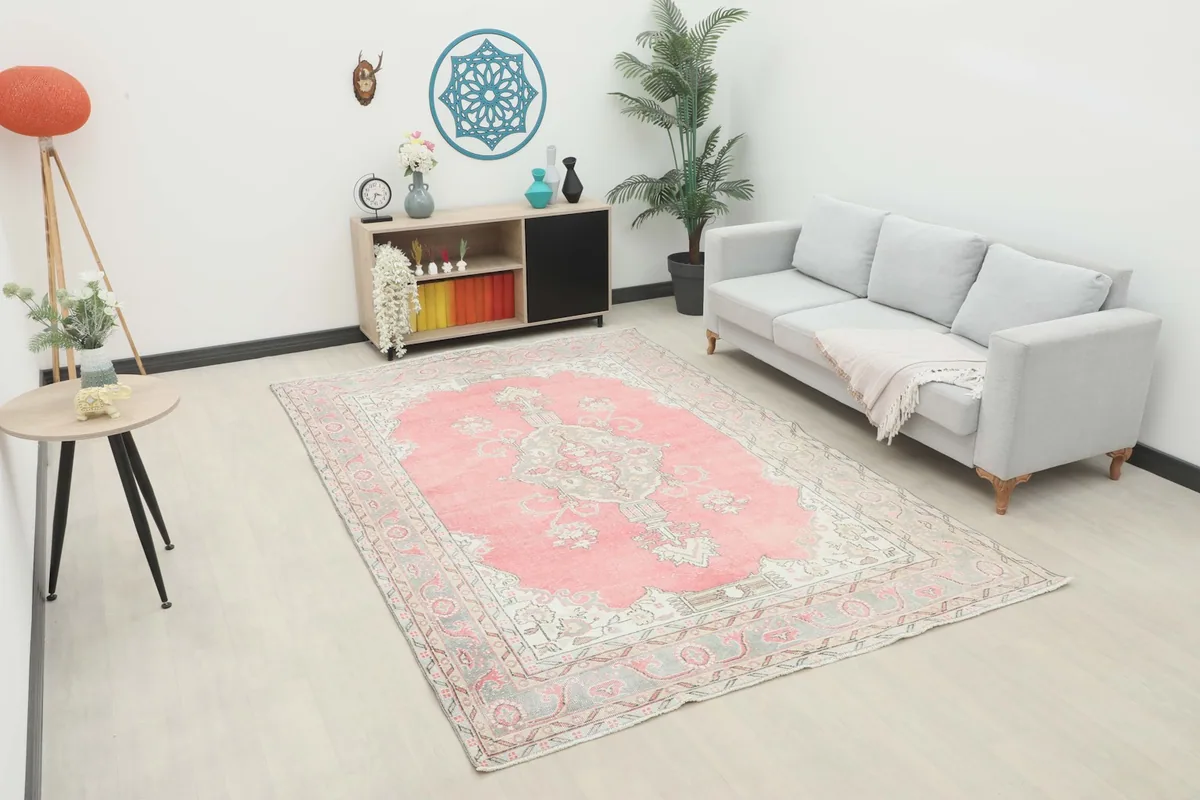 Vintage pink and gray rug placed in a modern living room setting with a light gray sofa