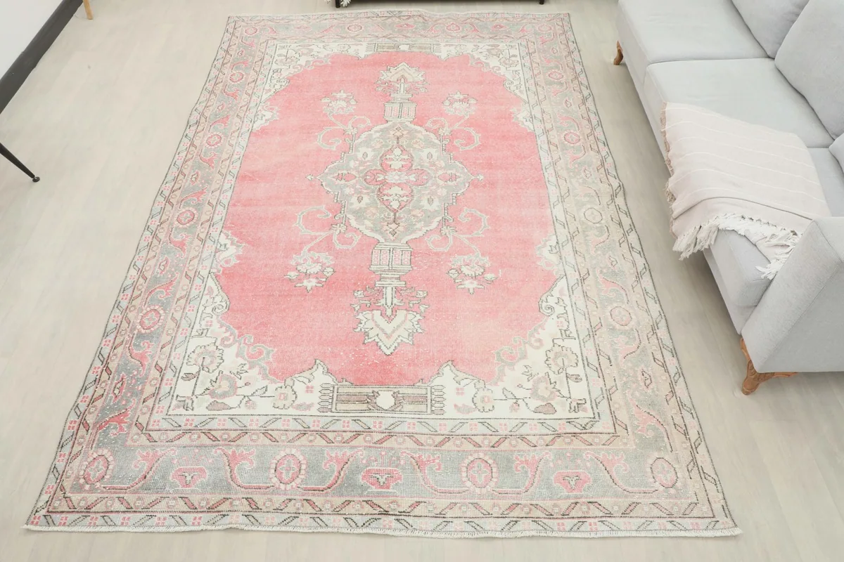 Full overhead view of the 6'9" x 10'0" vintage pink rug in a room, demonstrating its large size