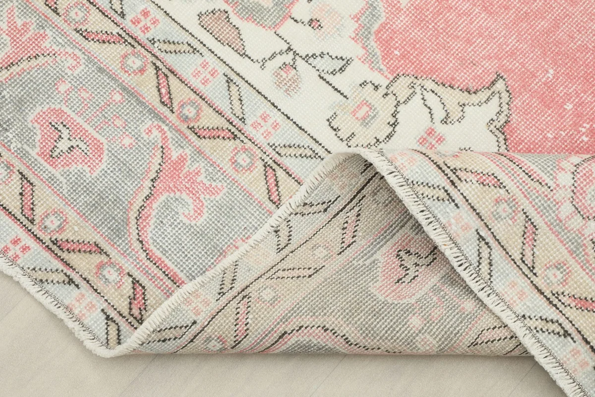 A section of the rug folded to show the thickness of the wool pile and the hand-knotted construction