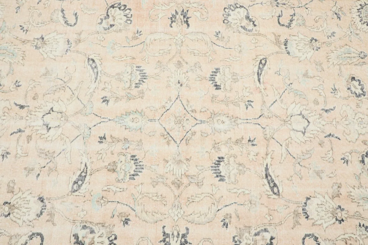 Close-up detail of the rose field with faded floral and vine motifs in soft colors.