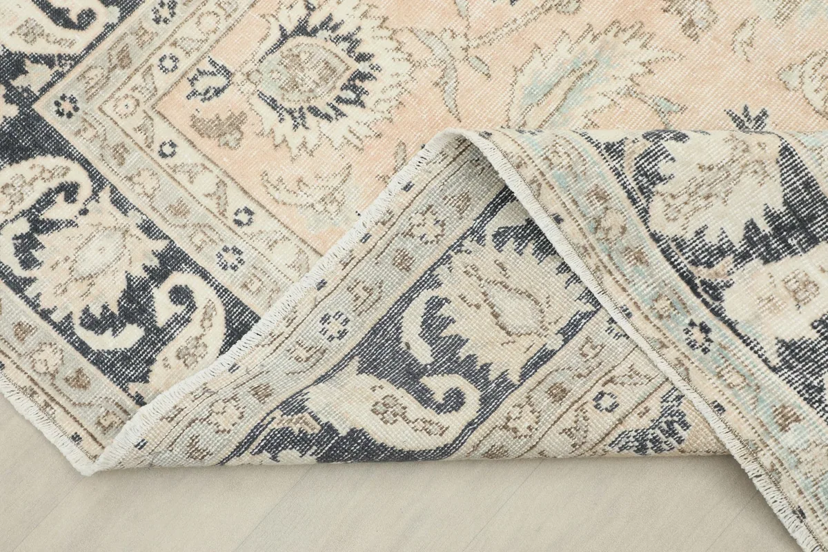 Corner of the rug folded back to show the construction and the reverse side.