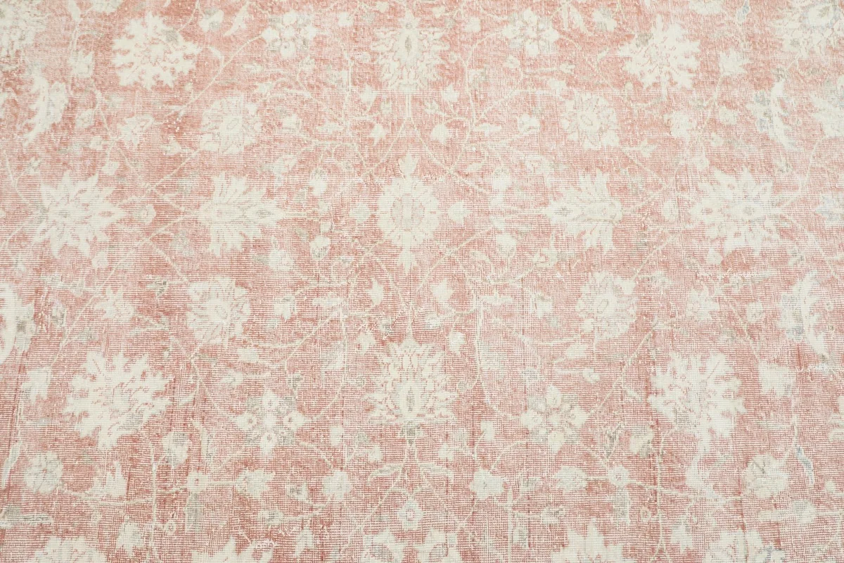 Close-up detail of the rose field with faded ivory floral motifs and low pile