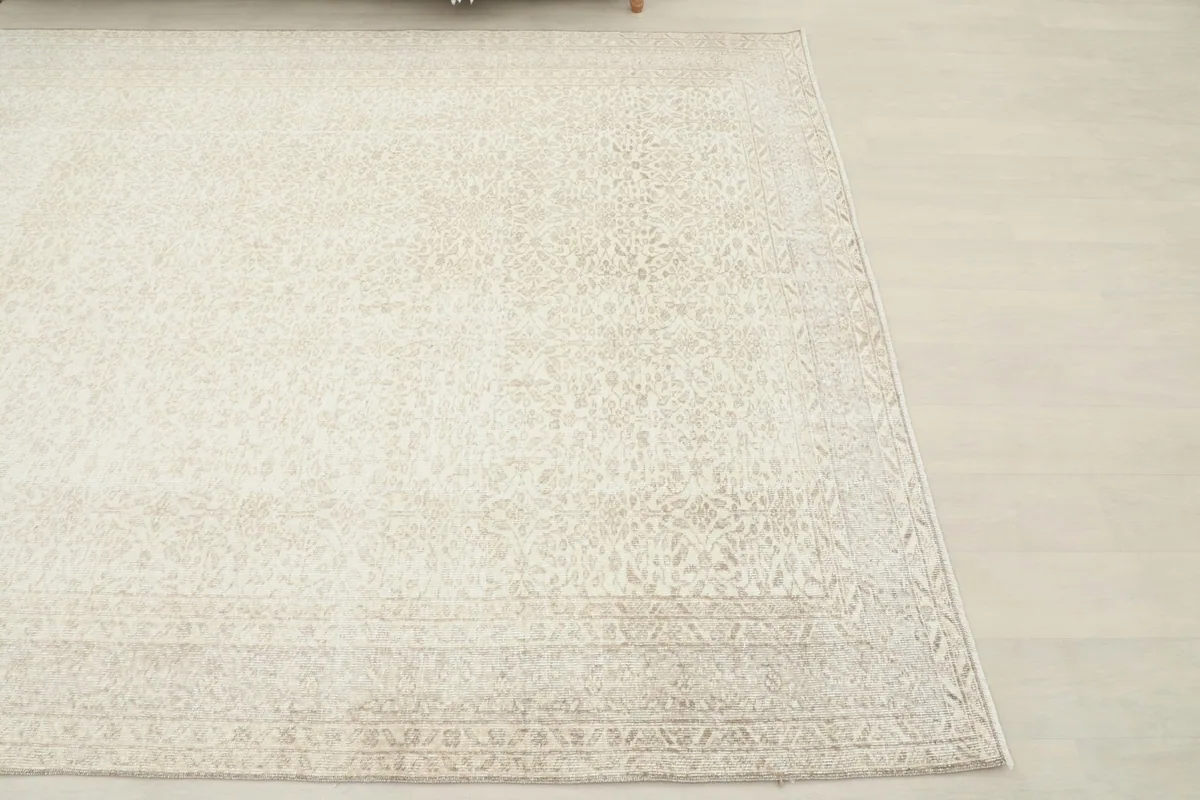 Corner view of the cream and beige rug, showing its soft color variations.