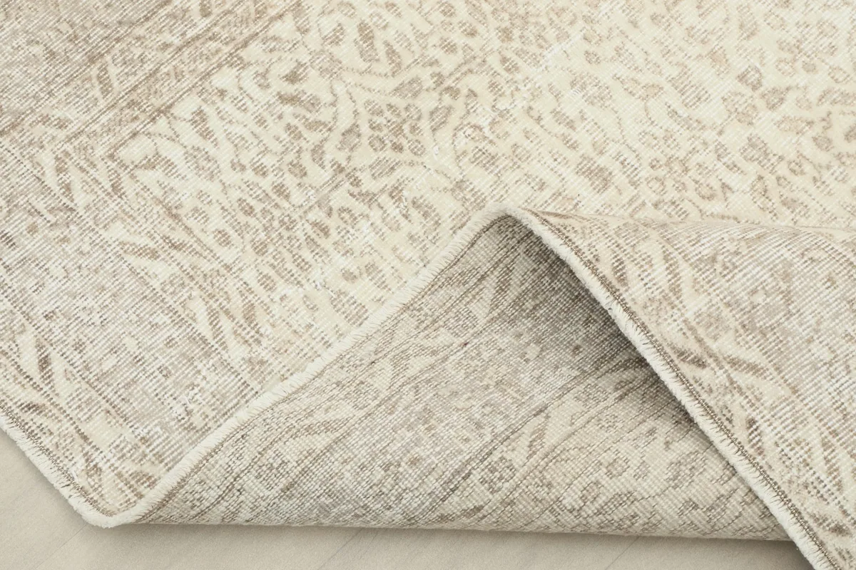 View of the rug folded to show the wool pile and cotton foundation.