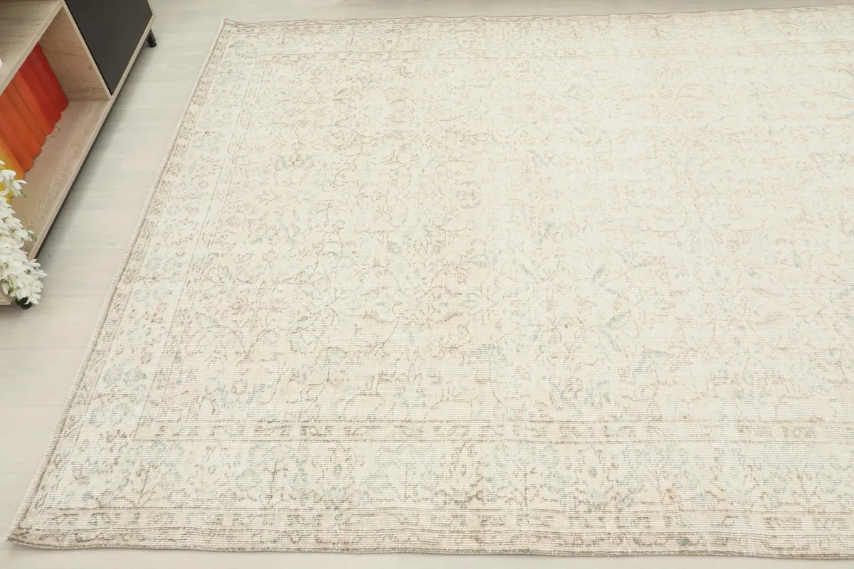 Overhead view of another corner of the rug, showing the consistent faded pattern