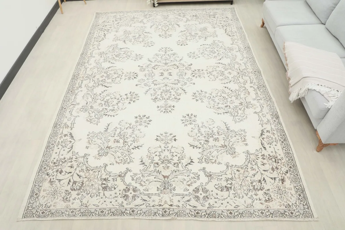 Full overhead view of the 7'5" x 10'5" vintage Anatolian rug in a room, showing its scale relative to a sofa.