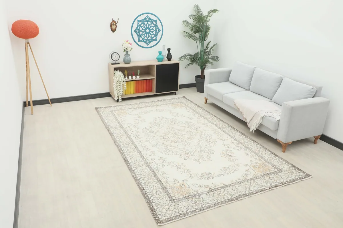 Ivory vintage rug displayed in a living room setting with a light gray sofa