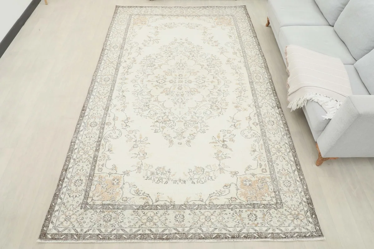 Overhead view of the ivory and gray area rug in a room, next to a light gray sofa