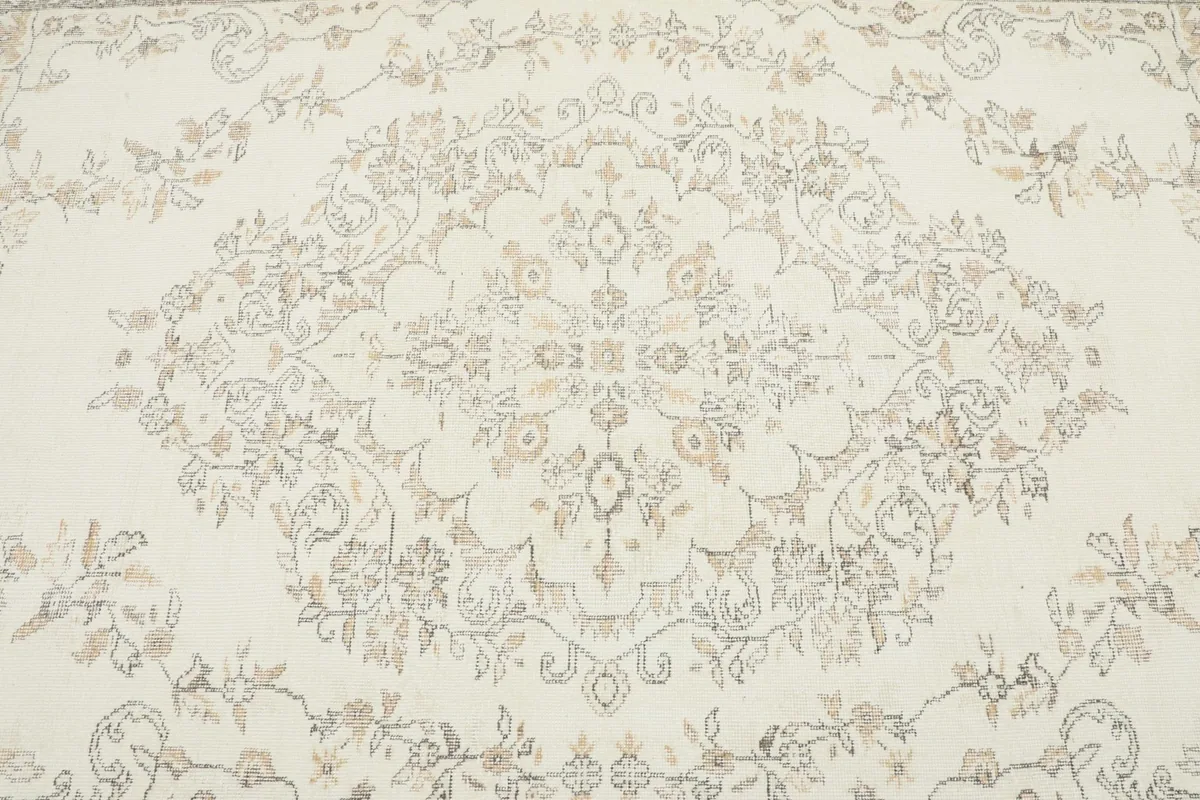 Close-up detail of the central medallion design on the ivory field