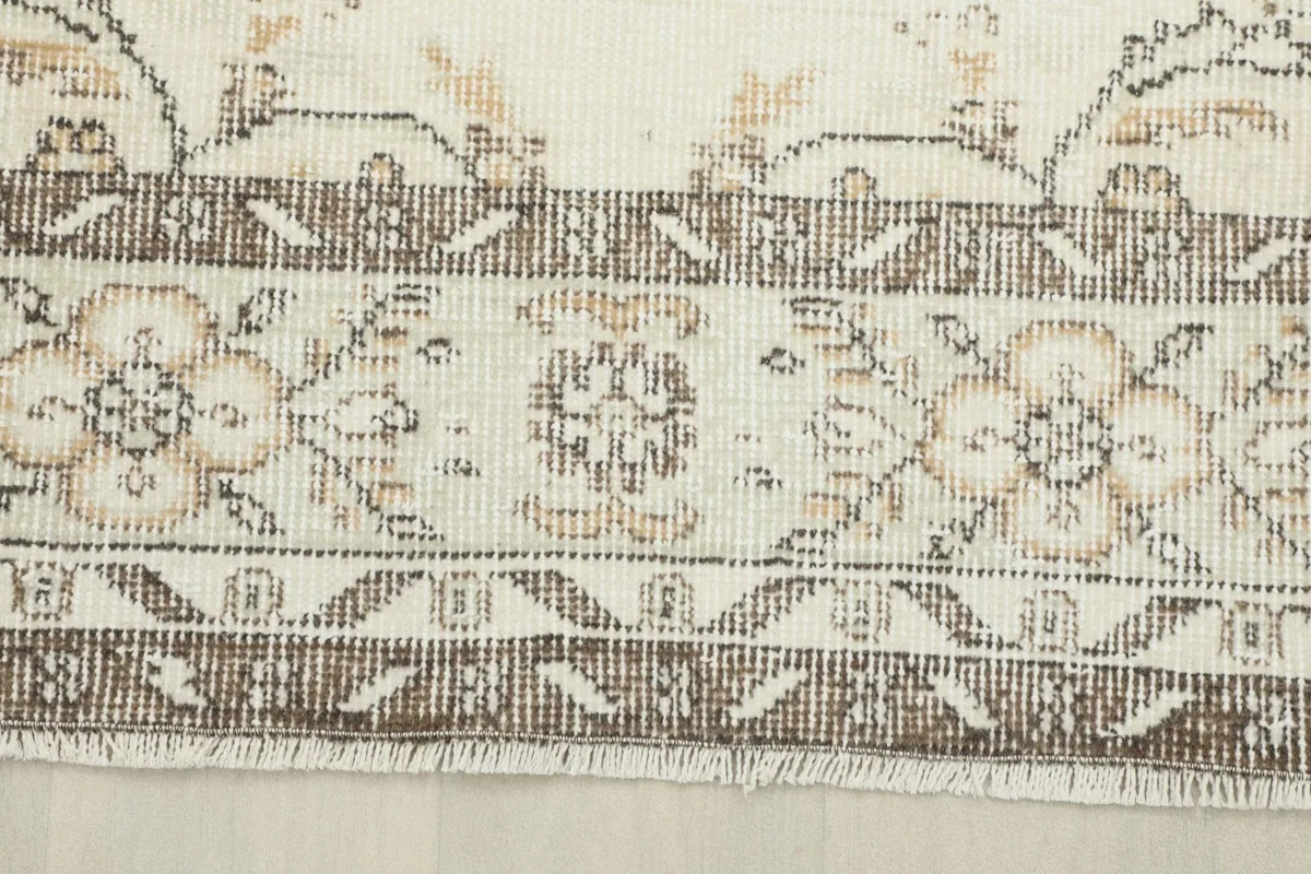 Close-up of the rug's border, showcasing the intricate floral and geometric patterns