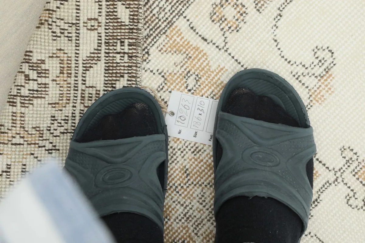 Close-up of the low wool pile and hand-knotted texture with a size tag