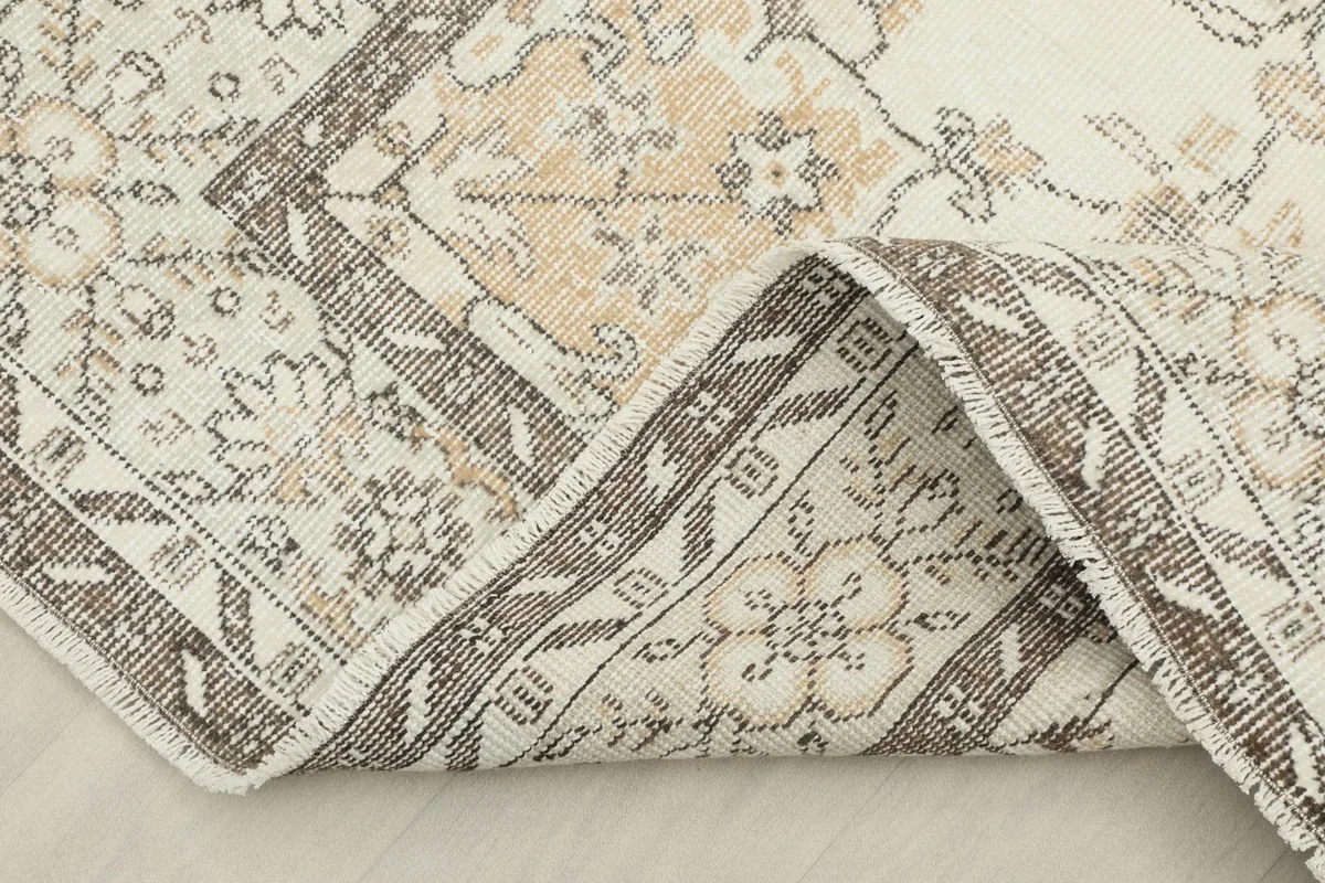 Folded corner of the rug, showing the reverse side and knotting detail