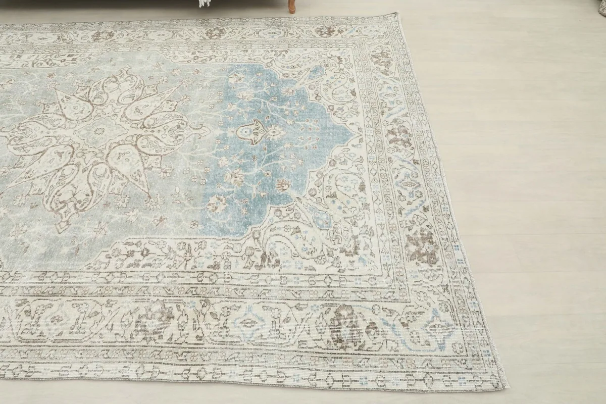 Corner view of the vintage rug, highlighting the soft color variations and low pile.