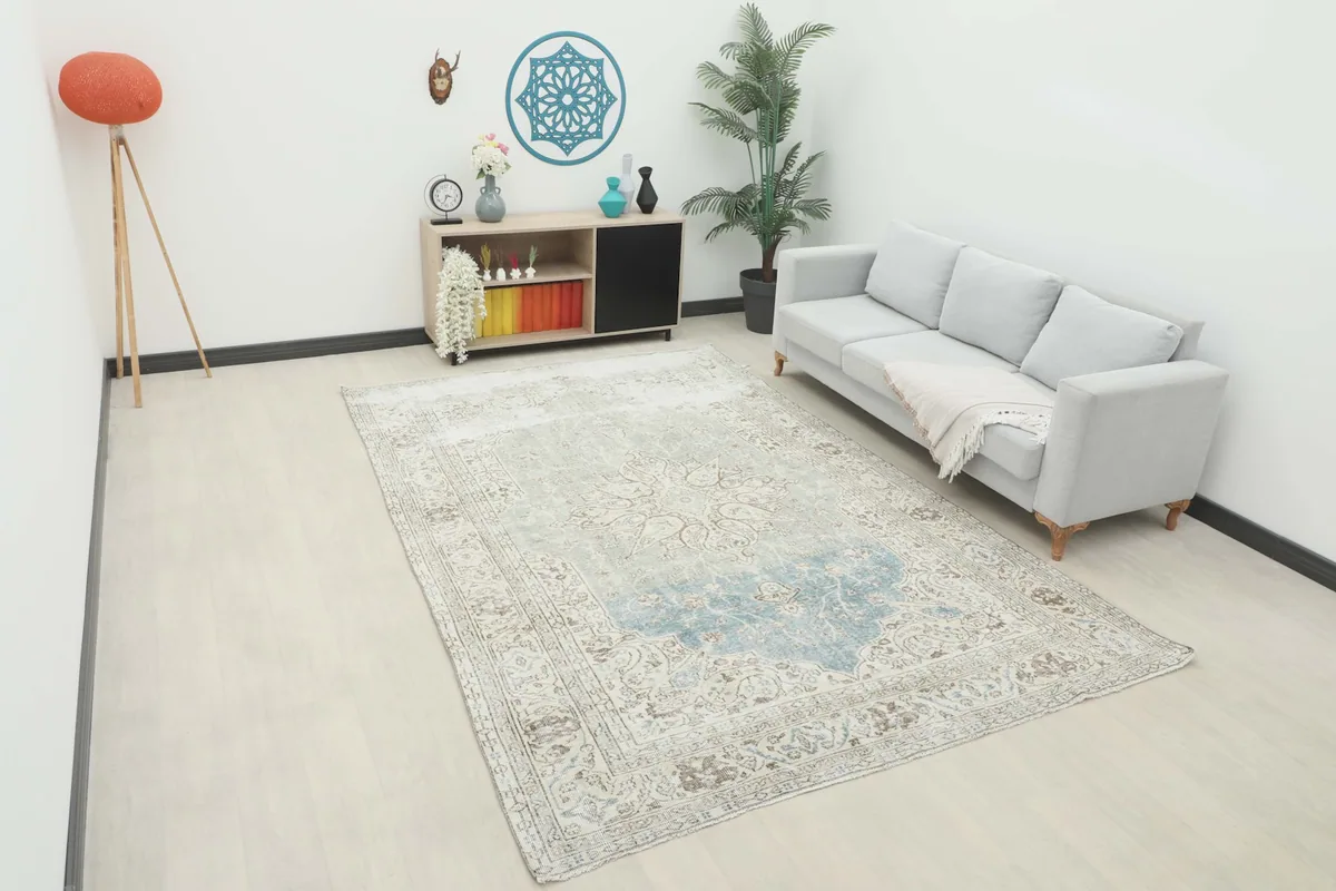 Large vintage rug displayed in a modern living room setting with a light gray sofa.